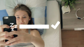 Schauspielerin Hannah Beckmann liegt im Bett und schaut auf ihr Smartphone, ein Still aus dem Spielfilm WatchME
