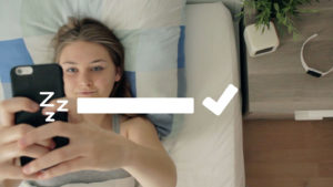 Schauspielerin Hannah Beckmann liegt im Bett und schaut auf ihr Smartphone, ein Still aus dem Spielfilm WatchME
